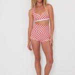 Woman wearing a red and white checkered bralette swim top and original betty bottoms on a white background