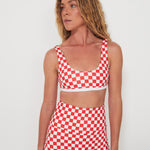 Woman wearing a red and white checkered two-piece swimsuit against a plain background