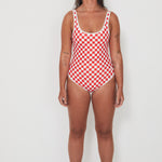 Woman wearing a red and white checkered swimsuit on a white background