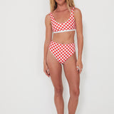 Woman wearing a red and white checkered bikini set on a white background