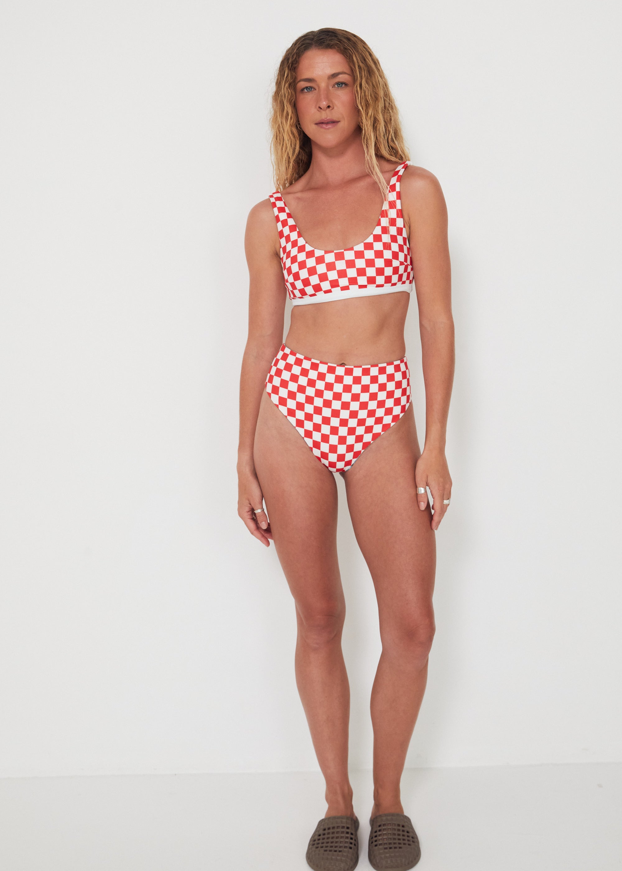 Woman wearing a red and white checkered bikini set on a white background