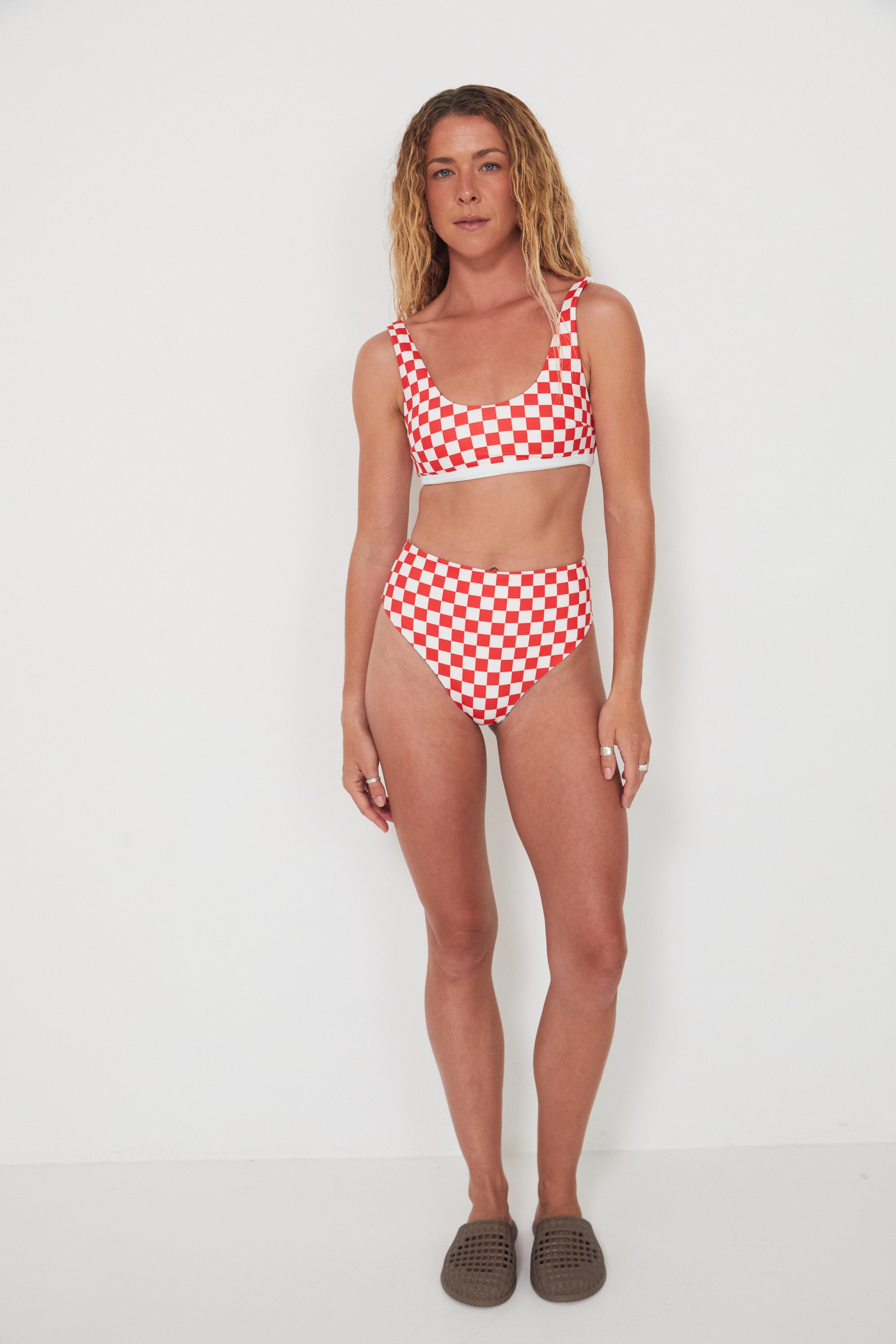 Woman wearing a red and white checkered bikini set on a white background