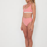 Woman wearing a red and white checkered bikini set on a white background