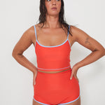 Woman wearing an red swimwear outfit on a white background