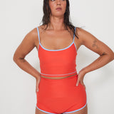 Woman wearing an red swimwear outfit on a white background