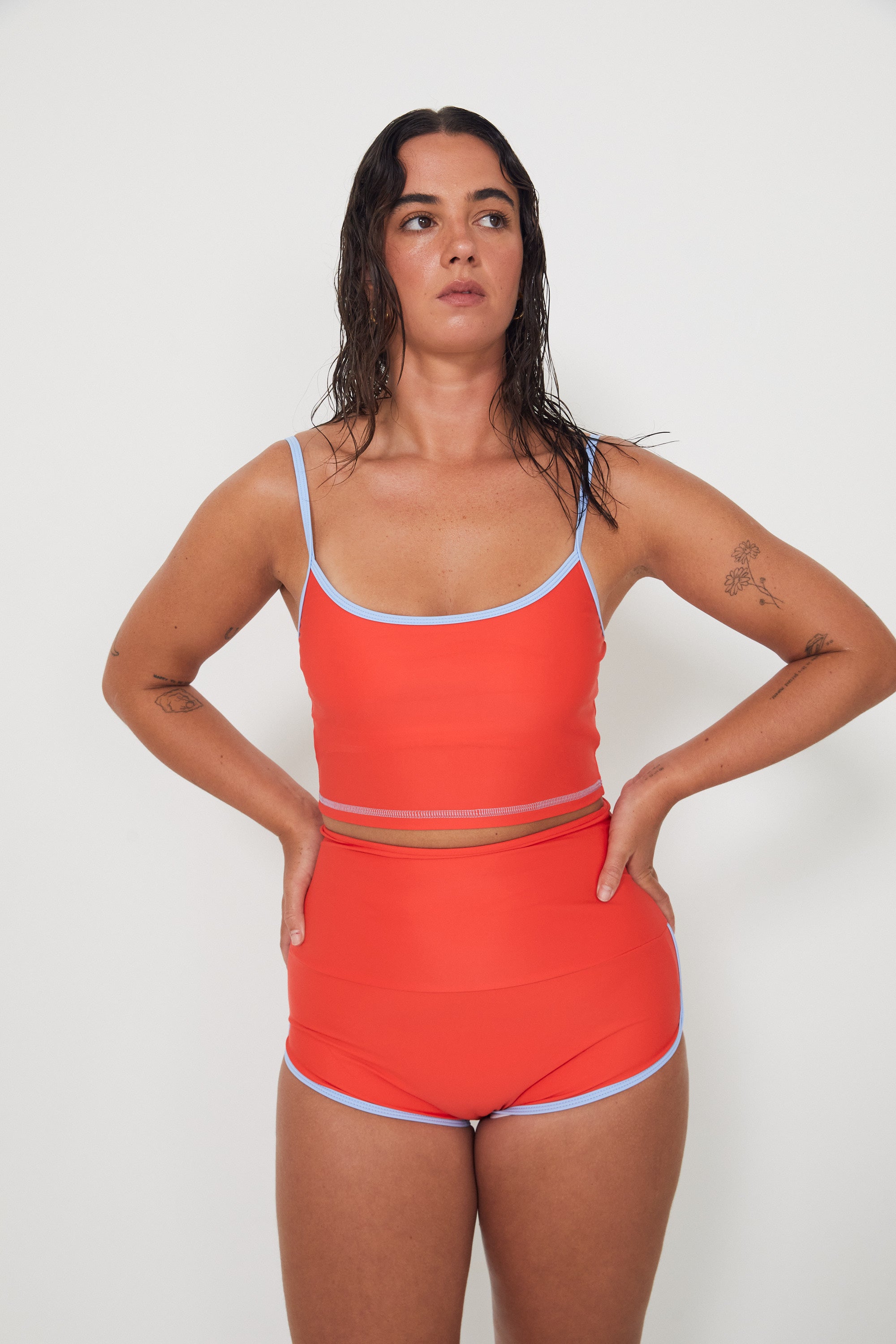 Woman wearing an red swimwear outfit on a white background