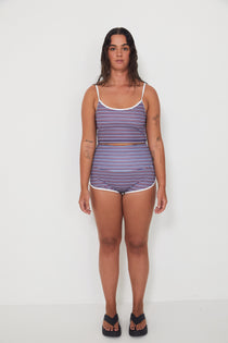 Woman wearing a merlot striped tankini surf top and betty bottom 2.0 shorts set on a white background