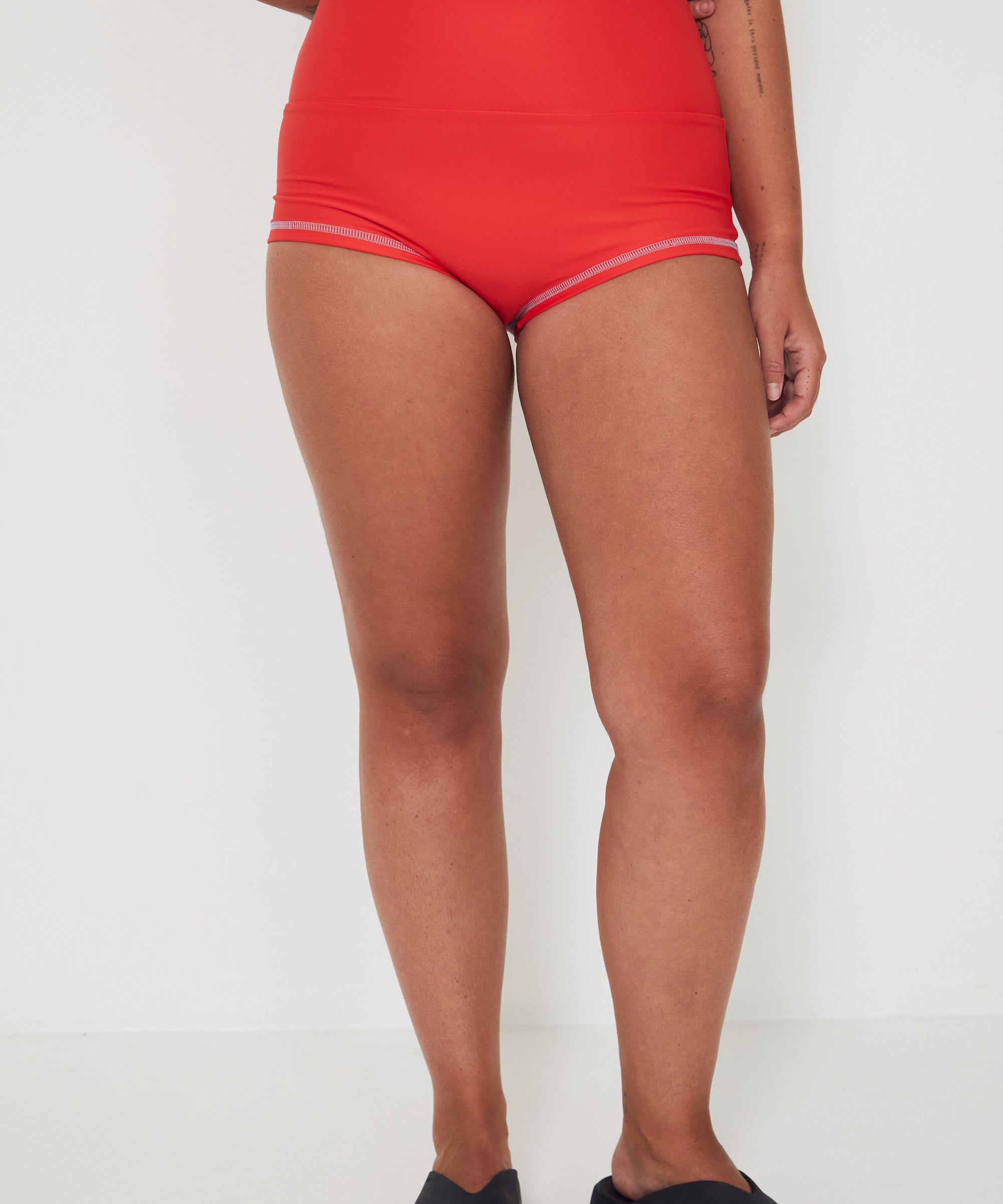 Person wearing red high-waisted original betty bottom shorts on a white background