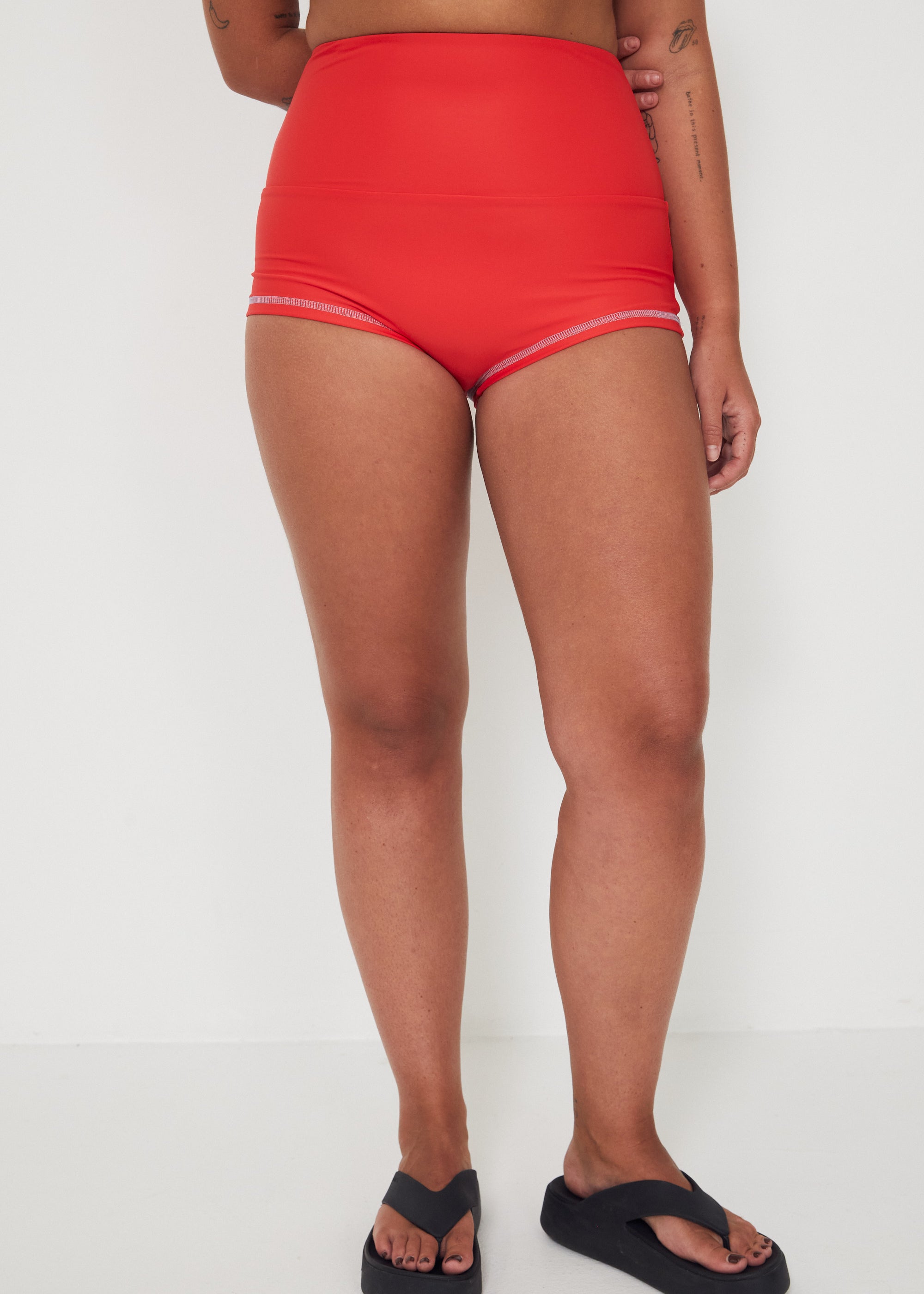 Person wearing red high-waisted original betty bottom shorts on a white background