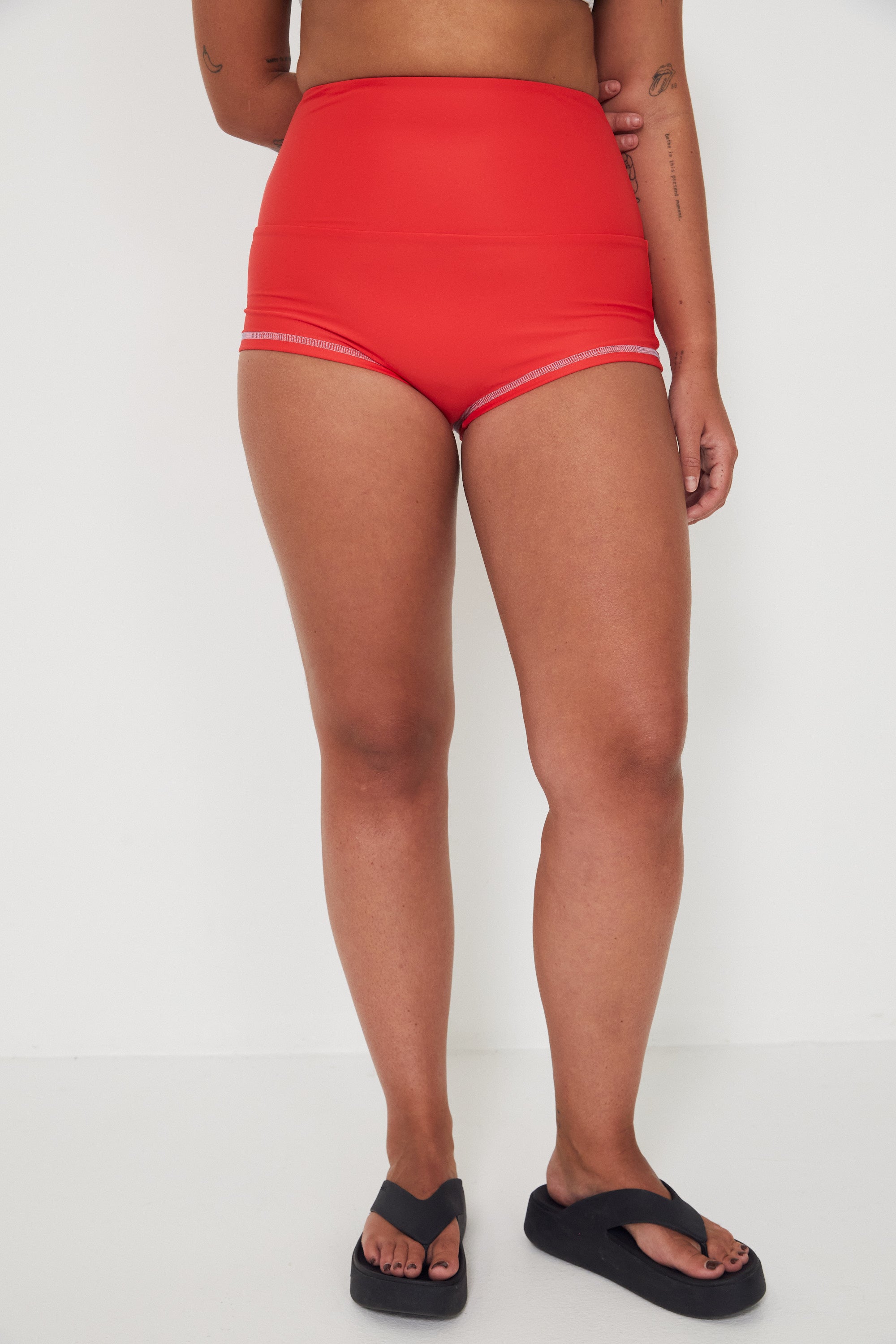 Person wearing red high-waisted original betty bottom shorts on a white background