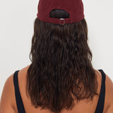Person wearing a maroon cap and black tank top with 'Salt Gypsy' branding on a white background