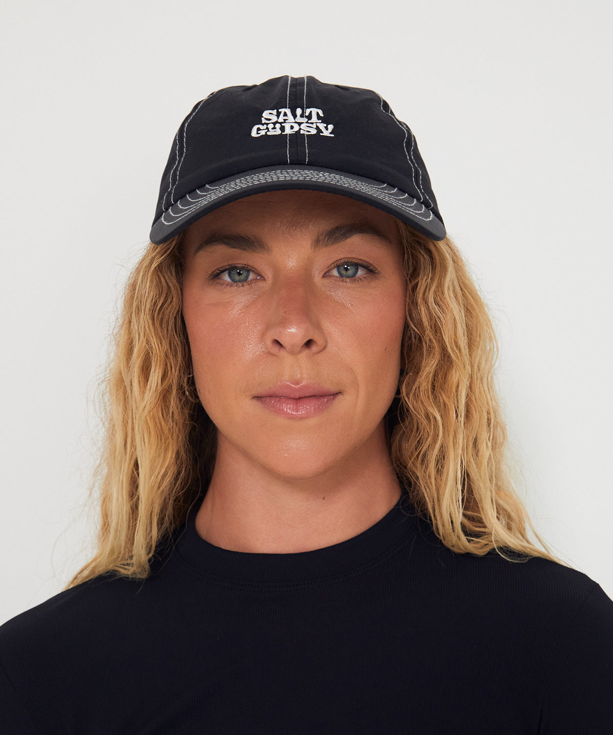 Person wearing a black dad nylon cap with 'Salt Gyspy' logo against a white background