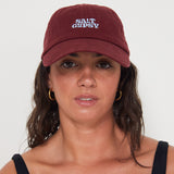 Woman wearing a maroon cap with a blue 'Salt Gypsy' logo on a white background